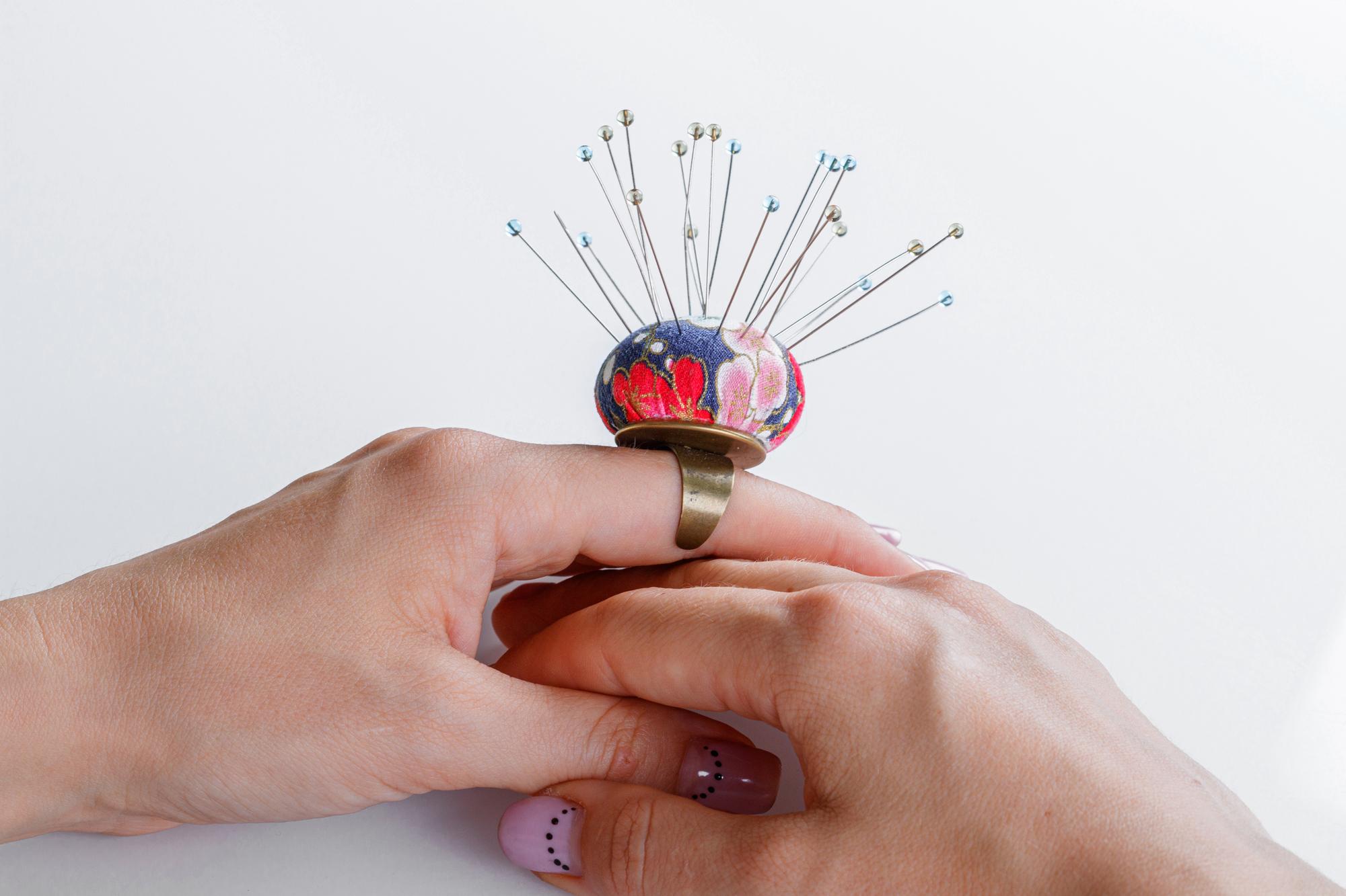 Hands stitching a modern embroidered motif